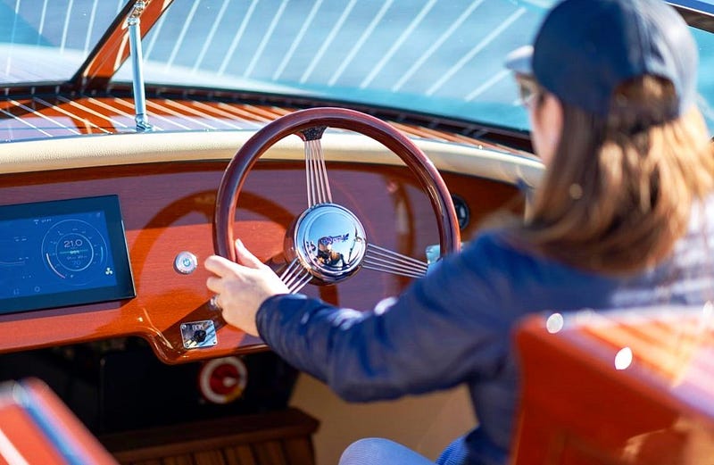 Captain steering a Hacker-Craft electric boat